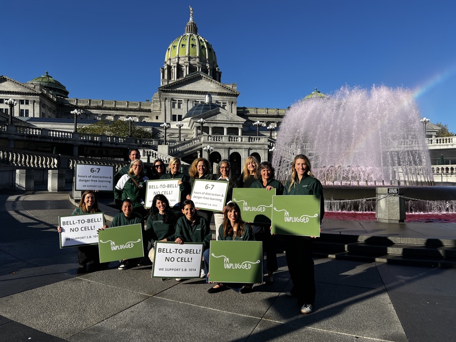 PA Unplugged members with bell-to-bell signs at the Capitol fountain in Harrisburg